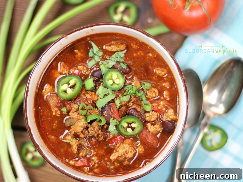 Crockpot Turkey Chili in a bowl topped with sliced jalapeño and cilantro.
