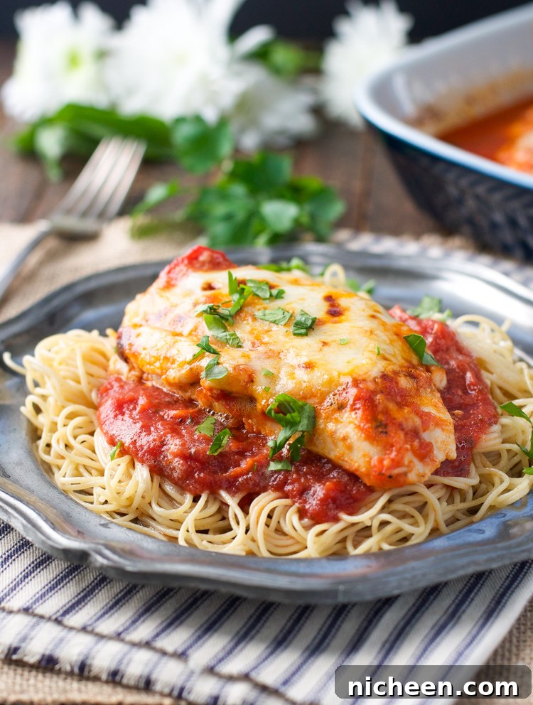 Baked chicken parmesan on a plate with a napkin underneath. 