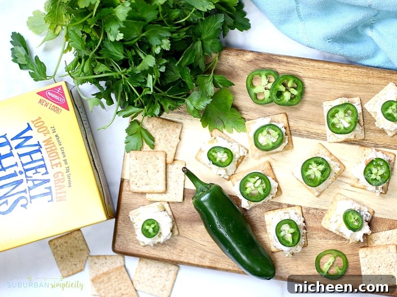 Crispy Jalapeno Popper Toppers Recipe 4 Jalapeno Popper Toppers on a cutter board with a fresh jalapeño and Wheat Thins.