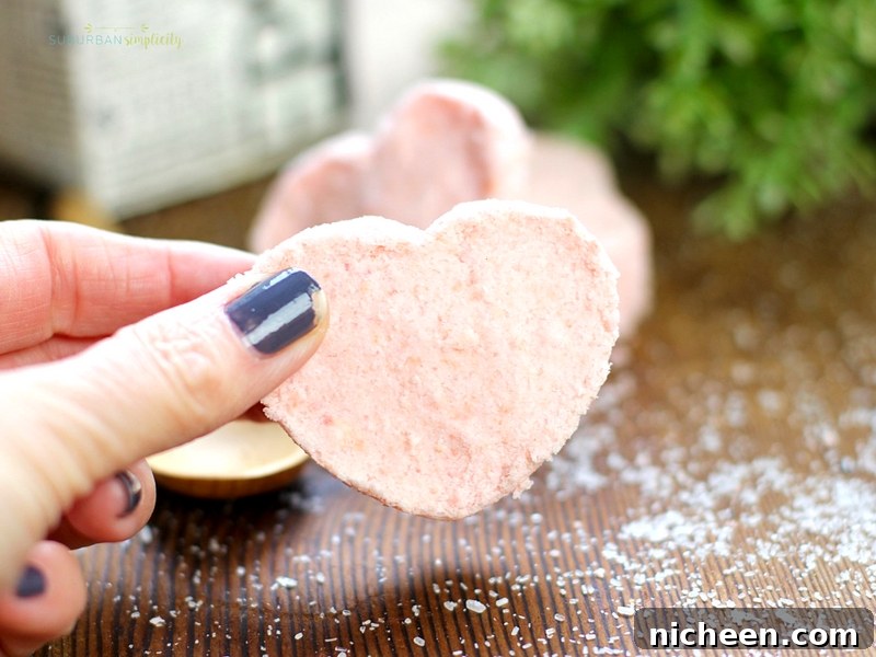 Fingers holding a freshly made bath bomb.