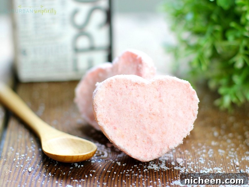 Pink heart shaped bath bombs with a spoon laying next to them.