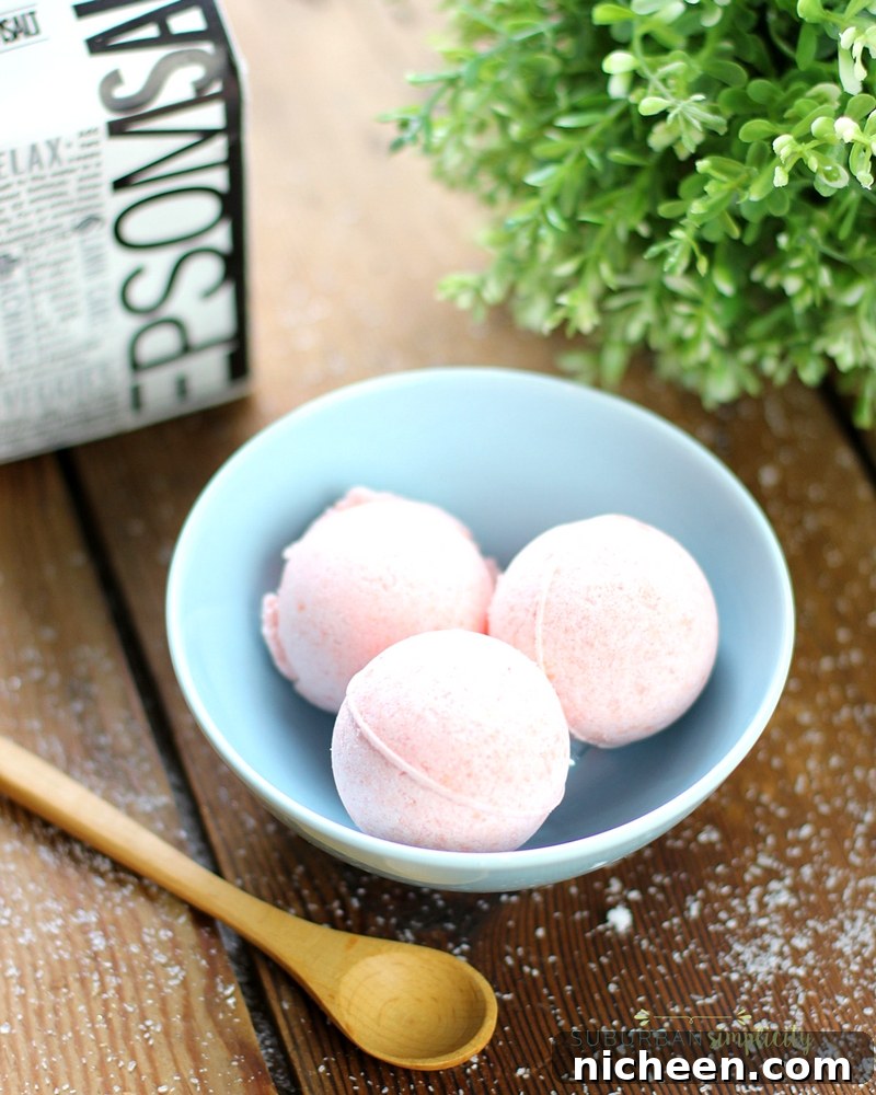 Homemade Bath Bomb Recipe with three bath bombs sitting in a bowl.