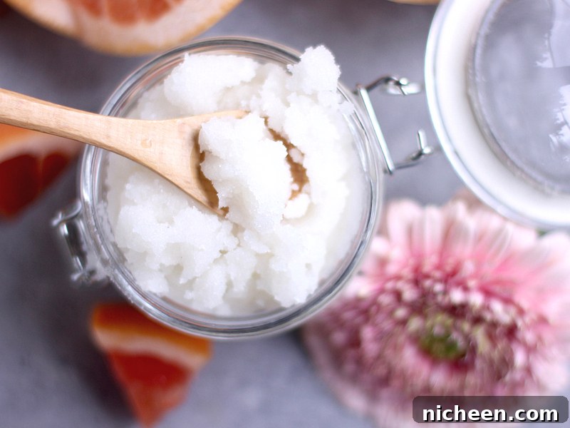DIY Grapefruit Sugar Scrub Recipe for Radiant Skin 3 Top view of a jar of grapefruit sugar scrub with a flower next to it.