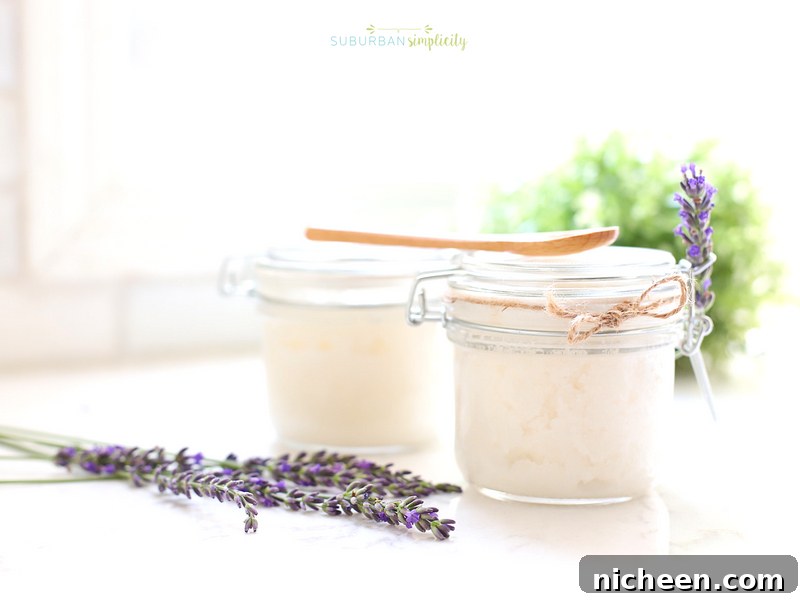 Lavender sugar scrub in jars with fresh lavender next to it.