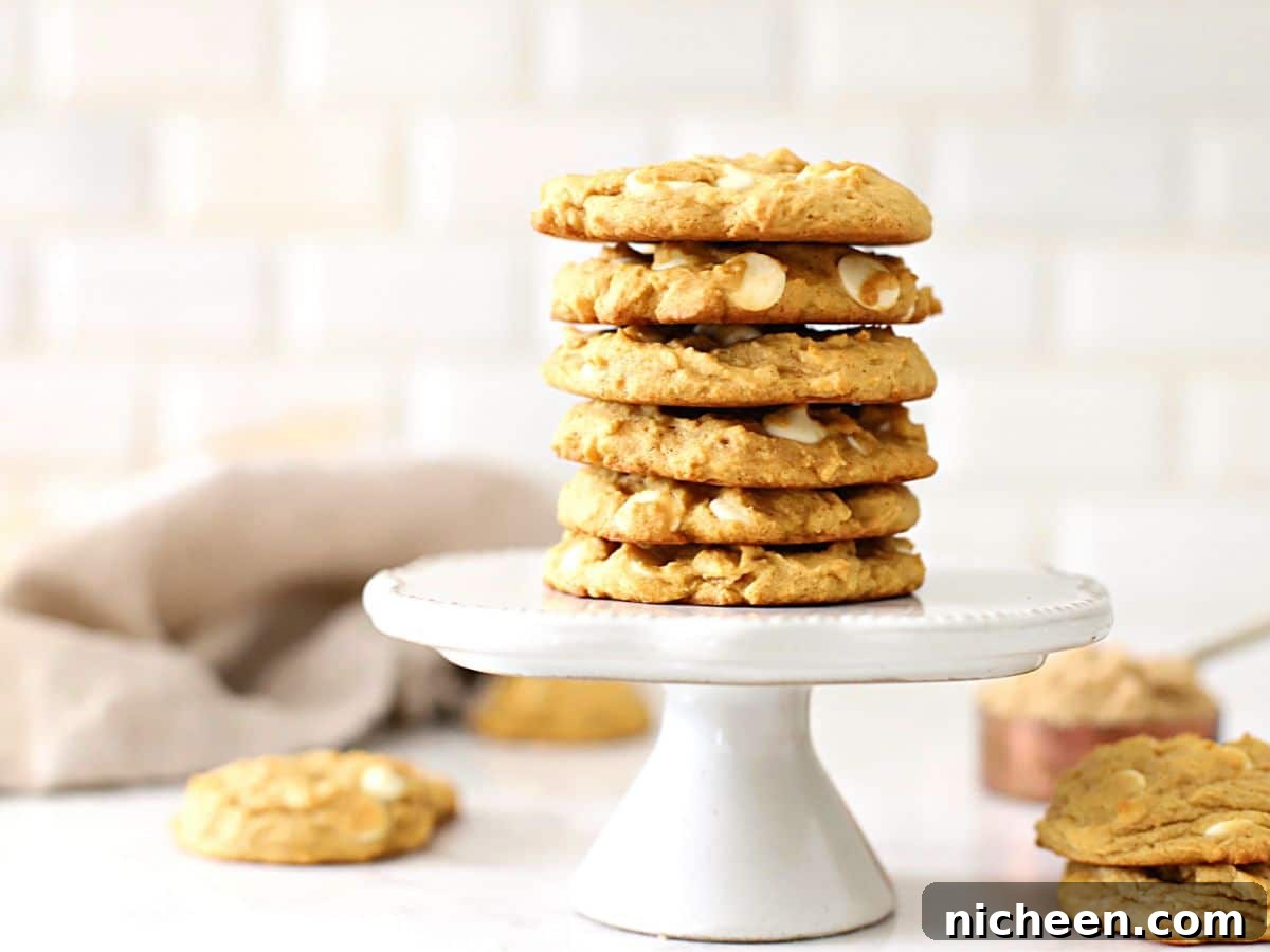 White Chocolate Chip Pumpkin Spice Cookies Recipe 2 A stack of pumpkin cookies on a cake stand.