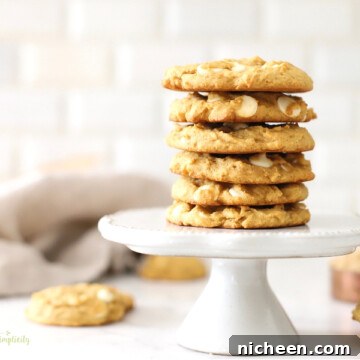 White Chocolate Chip Pumpkin Spice Cookies Recipe 8 Pumpkin spice cookies stacked on a cake stand.