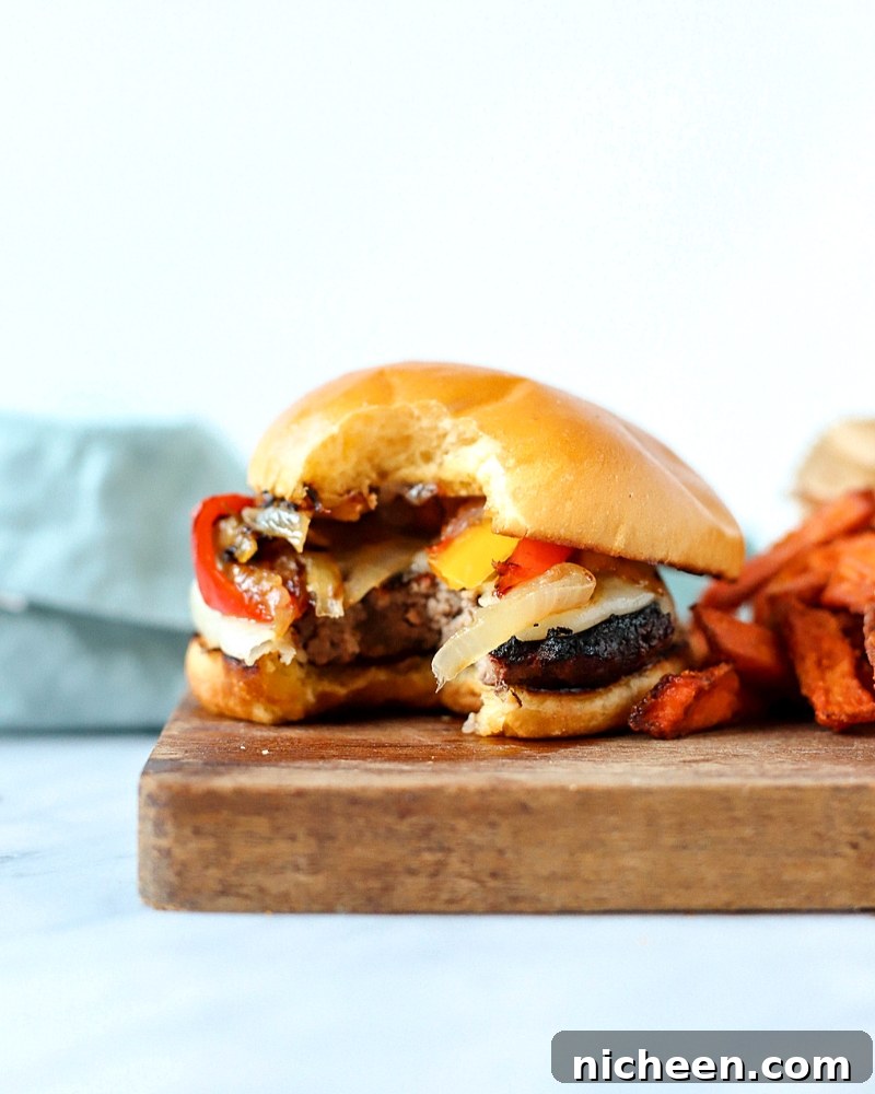 Homemade Philly Cheesesteak Burger Recipe 5 Burger on a cutting board with a bite out.