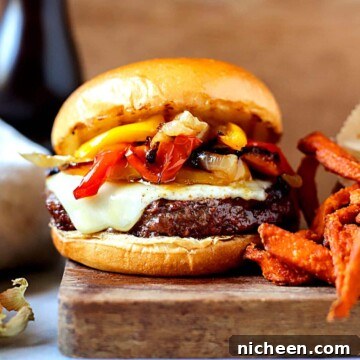 Homemade Philly Cheesesteak Burger Recipe 7 Cheesesteak burger with french fries next to it.