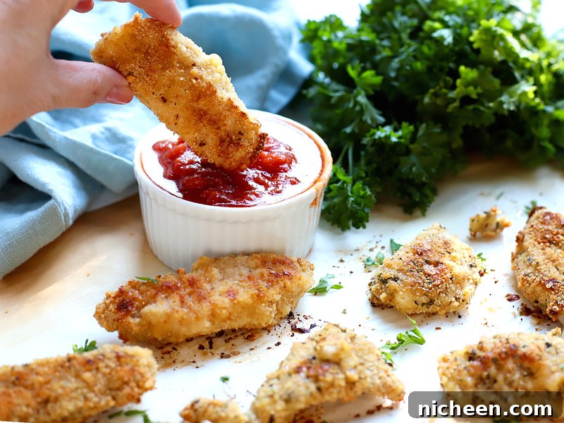 Easy chicken tenders being dipped in Marinara sauce.