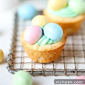 Cookie cup filled with frosting topped with colorful chocolate candies.