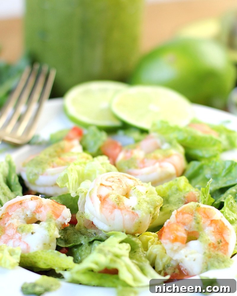 Healthy salad on a plate with a fork in the background.