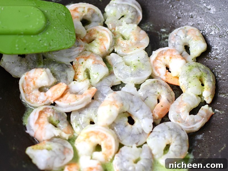 Raw shrimp cooking in a pan.