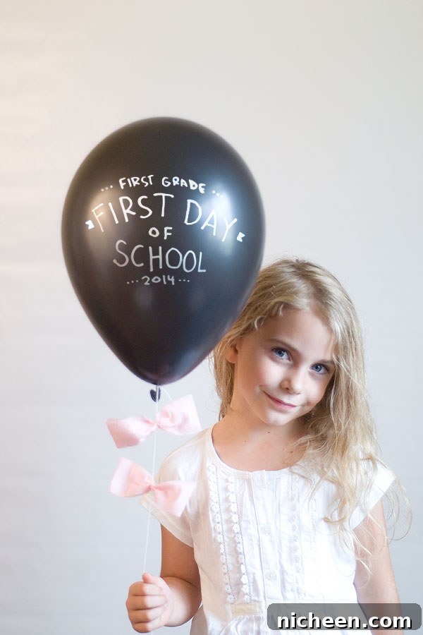 17 First Day of School Photo Ideas and Poses 11 A little girl posing for a picture with a balloon
