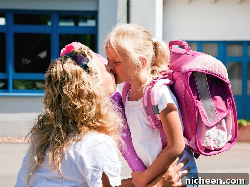 17 First Day of School Photo Ideas and Poses 9 A little girl standing in front of a building kissing her mom.