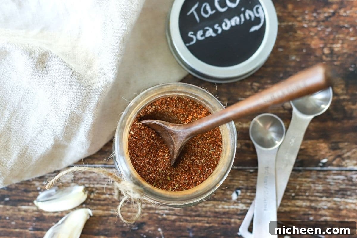 jar of taco seasoning with a spoon out of it.