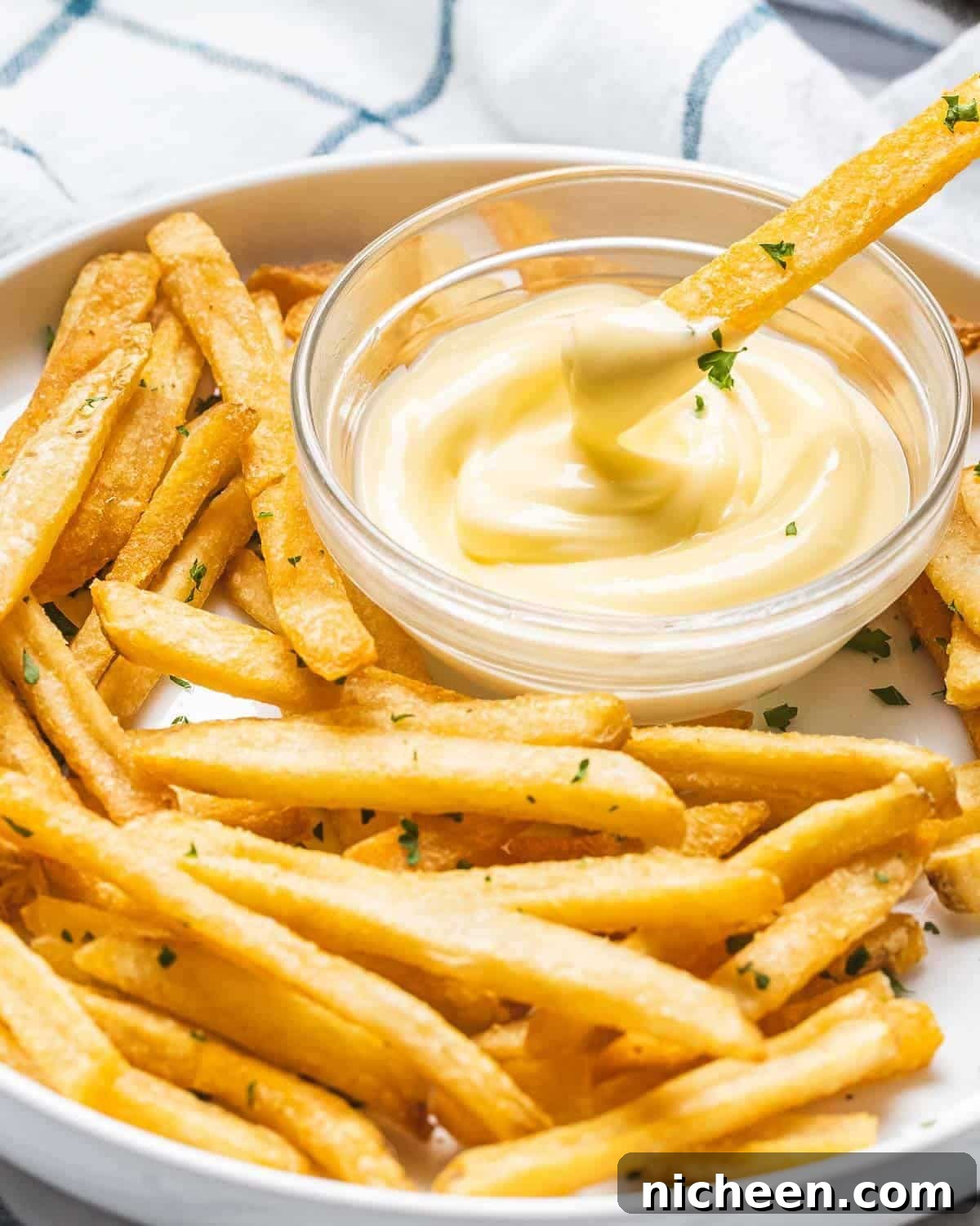 15 Irresistible Dipping Sauce Recipes for Chicken Tenders 10 French fries being dipped in garlic aioli.