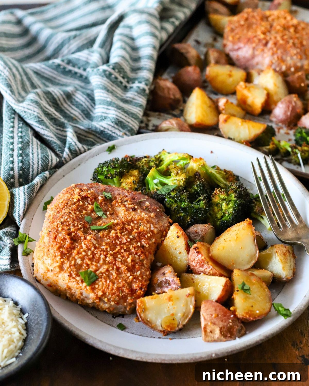 One-Pan Pork Chops with Crispy Potatoes 2 Plate with baked pork chops, potatoes, and broccoli.