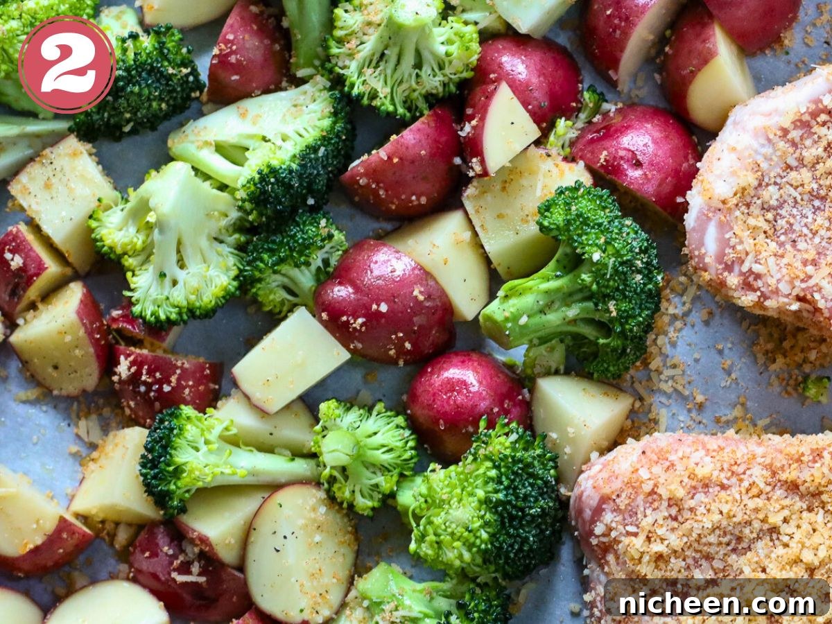 One-Pan Pork Chops with Crispy Potatoes 5 A sheet pan full of cut potatoes and broccoli.