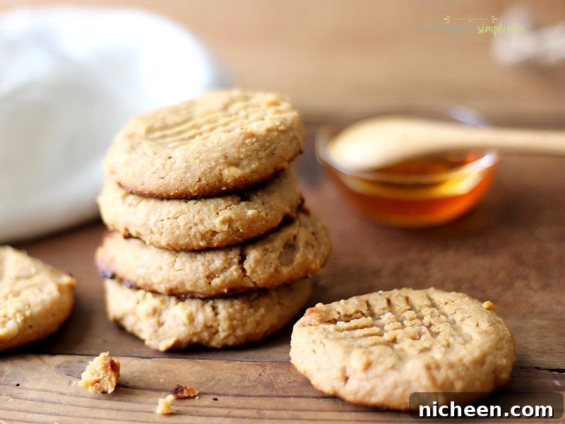 Peanut Butter Cookies on a counter with honey in the background.