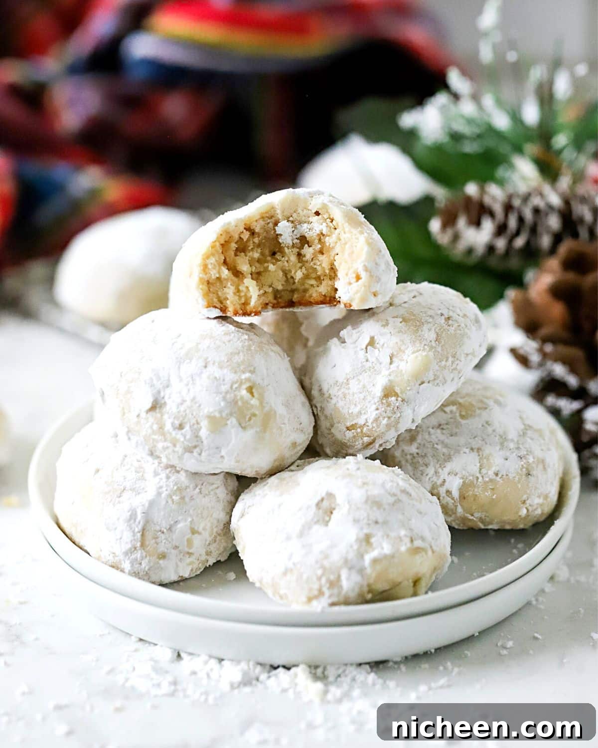Snowball cookies stacked on a plate.