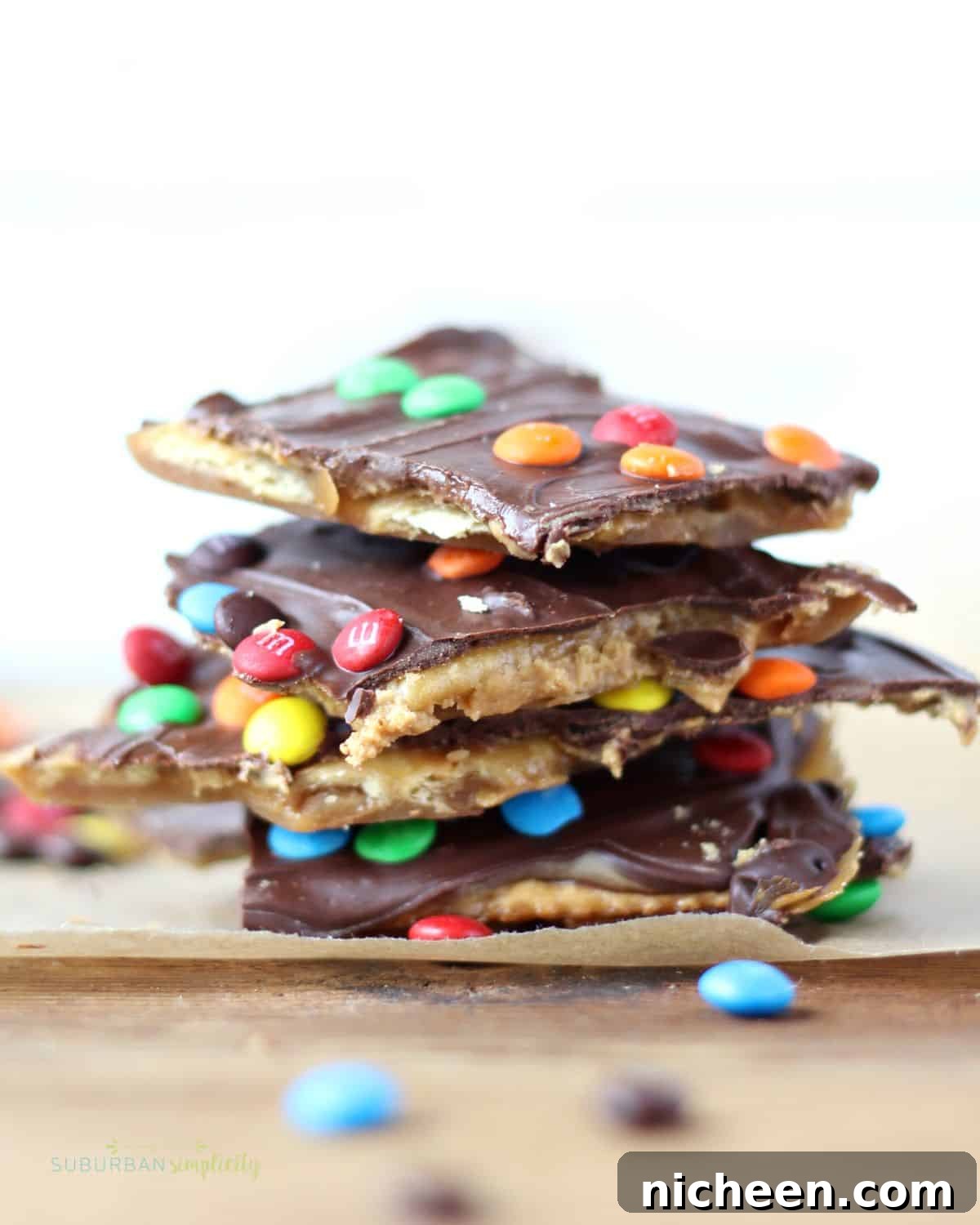 Five pieces of Saltine toffee with M&Ms stacked on each other.