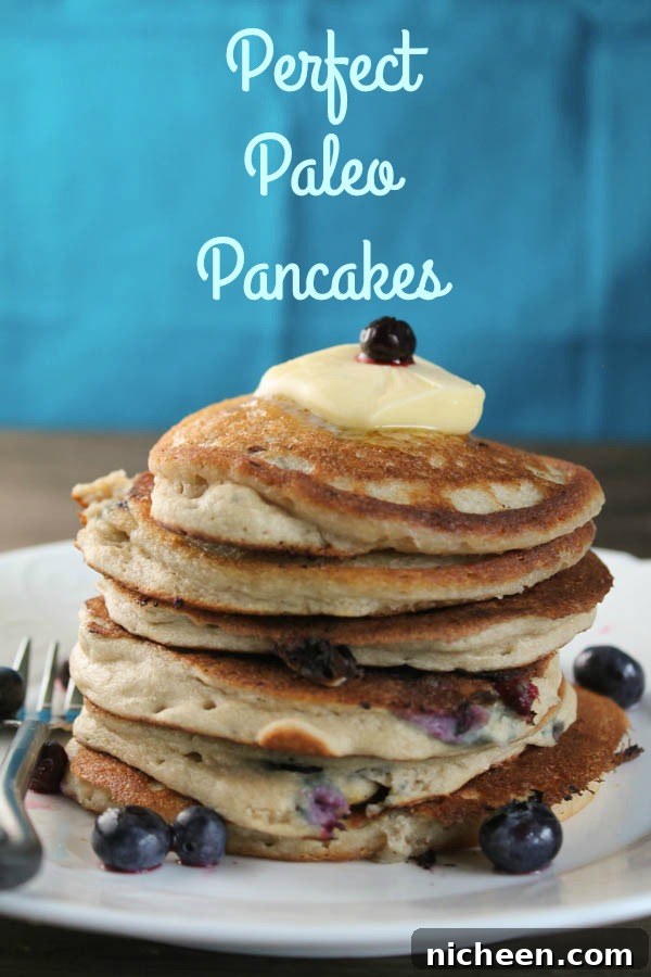 Perfect Paleo Pancakes, pancakes stacked on a plate with blueberries and butter on top